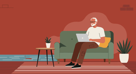 Senior man with glasses and a beard sitting comfortably on a green sofa, focused on working or browsing his laptop at home. Modern digital lifestyle and remote connectivity.