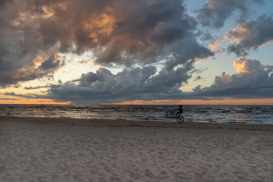 Cyclist at sunset by the sea.