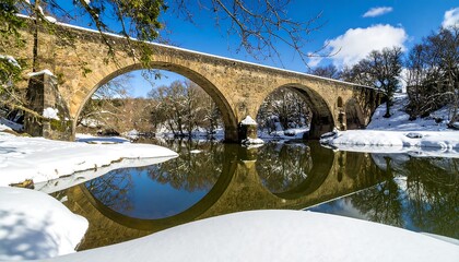 Stone bridge over a snow-covered river