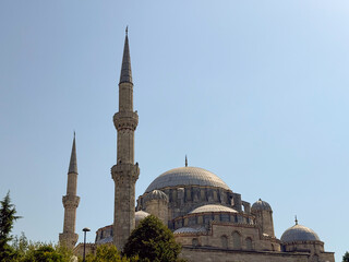 Historic mosque with tall minarets and domes under clear blue sky. Religion, architecture, and cultural heritage symbolizing spirituality, tradition, and monumental landmark.