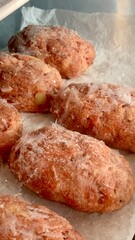 Delicious pastries are arranged on parchment paper, featuring a crisp golden-brown exterior and a flaky texture, ready to be enjoyed in a cozy bakery setting