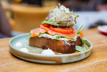 toast with salmon cheese and lettuce with vegetables in a restaurant for breakfast