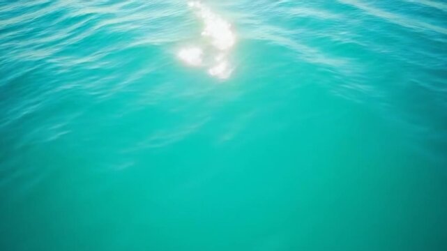 Vertical aerial view on sea water surface, camera flies over clear sea water. Sun glare. Abstract nautical summer ocean nature. Holiday, vacation and travel concept. Nobody. Vertical video
