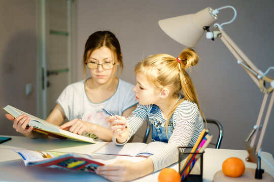 Mother and daughter doing homework together, styding and learning concept, doing tasks for school - Powered by Adobe