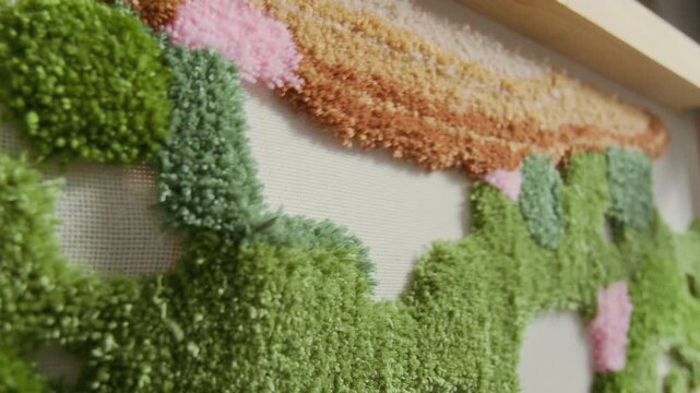 Close up shot of rug tufting process with tufting gun punching thread through canvas and creating colorful design, copy space