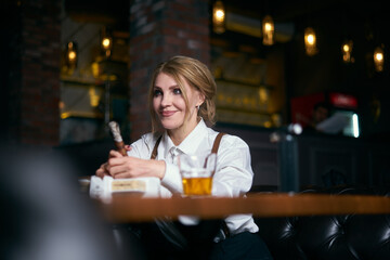 Senior attractive female gangster smoking cigar over dark background in restaurant
