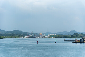 Obraz premium View of the Panama Canal entrance with calm waters and green riverbanks.