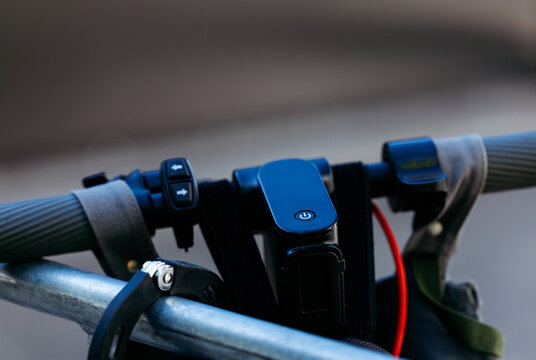 Close-up of electric scooter handlebar with control buttons and digital display