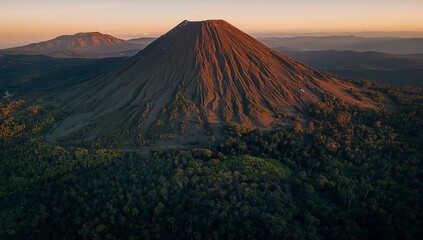 Majestic Volcano Summit Bathed in Golden Hour Light, Lush Green Forest Below