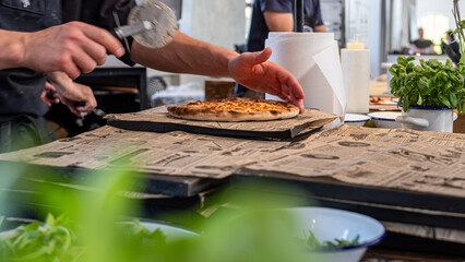 Fresh homemade pizza being sliced in a cozy restaurant, showcasing crispy crust, aromatic toppings, and rustic presentation, perfect for food lovers to enjoy