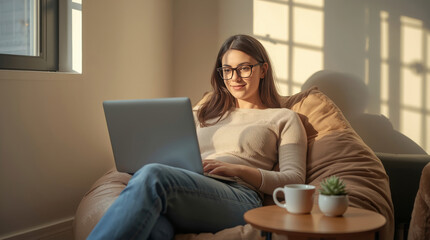 Fototapeta premium The Digital Nomad's Lifestyle. young, confident female digital nomad in her late 20s is sitting comfortably on a bean bag chair in a cozy, sunlit co-working space. She is working on her laptop