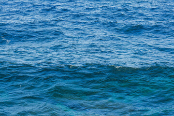 Sea surface aerial view. Background shot of clear sea water surface. Blue sea water in calm. Sea texture. Background blue waves of the ocean