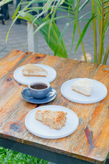 Delicious coffee and cake slices on a rustic wooden table for a relaxing cafe experience