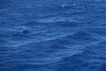 Sea surface aerial view. Background shot of clear sea water surface. Blue sea water in calm. Sea texture. Background blue waves of the ocean
