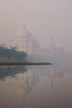 View of Taj Mahal at sunrise reflected in Yamuna river with fog, Agra, Uttar Pradesh, India