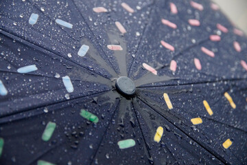 Close-up image of a colorful umbrella with raindrops on it