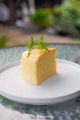 Enjoy a slice of delicious Japanese cheesecake topped with fresh mint in tranquil setting
