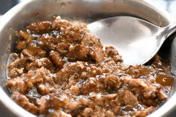 Wet cat food with spoon in a aluminium bowl.