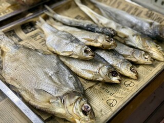 A delightful dried fish exhibit, beautifully decorated on an unknown newspaper background, demonstrates traditional ways of selling and preserving products. Appetizer for beer