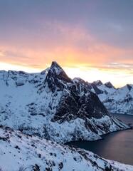 Snowy mountains at sunset over fjord