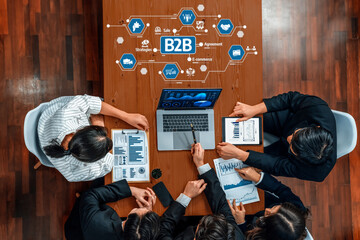A professional business meeting featuring a team analyzing B2B strategies, showcasing collaboration through technology and data-driven discussions around innovative solutions. Amity
