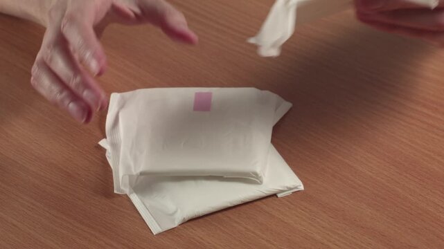Close-up of woman preparing sanitary pads, recorded with ambient sound.