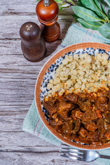 Hungarian goulash with spaetzle on rustic wooden table