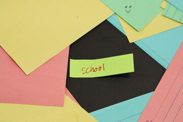 school written on sticky note surrounded by colored paper