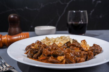 Delicious hungarian goulash with spaetzle accompanying red wine