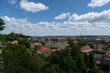 Fototapeta premium Scenic cityscape view on a sunny day with blue sky and clouds. Architecture and greenery dominate the horizon.