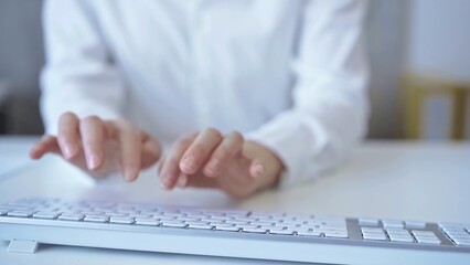 Businesswoman with white blues is working on a computer keyboard in an office setting. Business concept