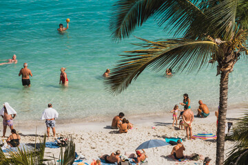 People enjoying the white sand beach and palm trees