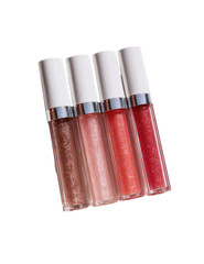 Four tubes of shimmery lip gloss in various shades of pink and peach