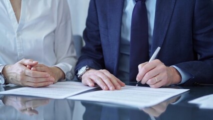 Business people wearing suits signing important documents during a corporate meeting. Win-win concept
