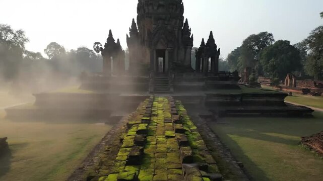 Ancient stone steps leading to misty temple ruins at sunrise