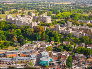 Aerial view of Windsor Castle surrounded by town buildings and lush green landscape