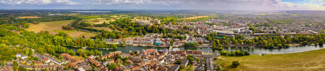 Aerial view of Windsor Castle surrounded by town buildings and lush green landscape