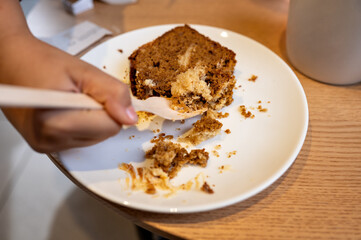 half-eaten piece of cake on white plate in cafe. High quality photo