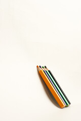 Four colored pencils arranged diagonally on a white background, symbolizing education, creativity, simplicity, and artistic inspiration.