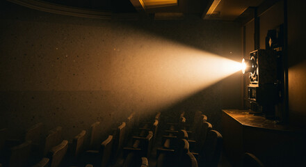 Vintage movie projector casting light in empty cinema hall  