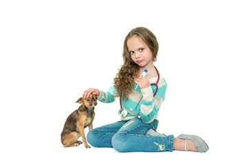 Obraz premium Little girl playing doctor with her dog. Veterinarian taking pet's temperature. White background.