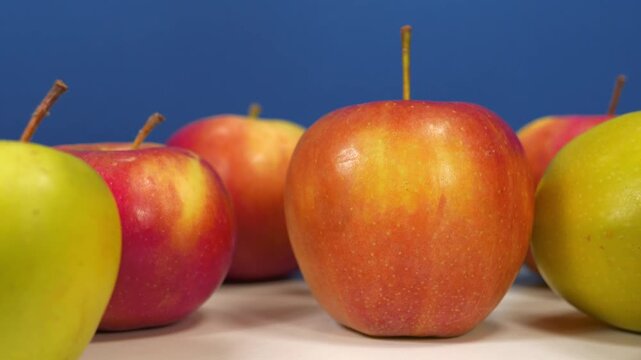 Red fresh ripe juicy apples at dark blue background, zoom-in video