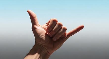 Hand Gesture Making Shaka Sign Against Bright Blue Sky