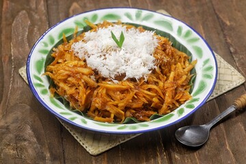 Sawut or pasrah is a snack made from coarsely grated cassava, then steamed until cooked, eaten with grated coconut.
