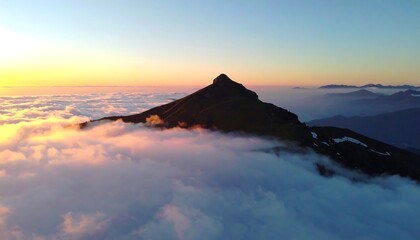 Mountain peak rising above a sea of clouds at sunrise