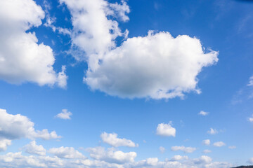 Beautiful blue sky with fluffy white clouds, perfect for background, wallpaper, or design projects.