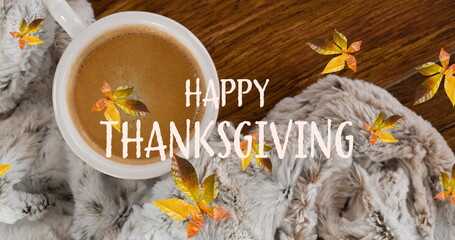 Image of happy thanksgiving text over autumn leaves and cup of coffee on wooden boards
