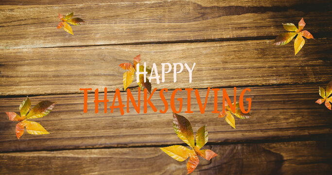 Fototapeta Image of happy thanksgiving text over autumn leaves on wooden boards
