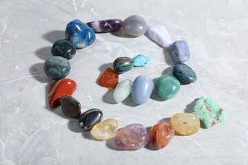 Many different healing stones on light grey table, closeup