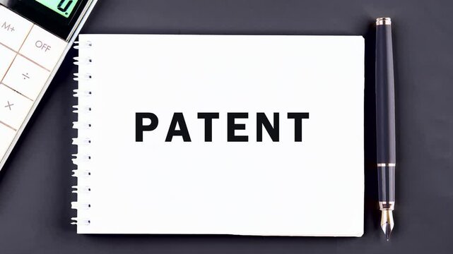 The appearance of the conceptual word PATENT on a blank piece of notebook paper. Patented patent copyright law business technology concept